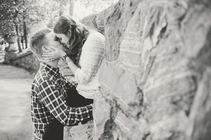 couple kissing on stone wall in piedmont park