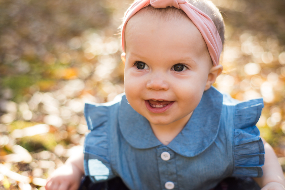 baby girl smiles during family session with You are Raven