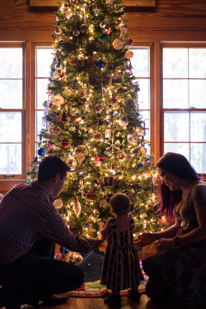 family looks at Christmas tree photographed by You are Raven