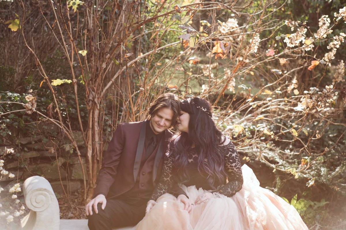 bride in pink wedding gown nuzzles groom in burgundy tux with You are Raven