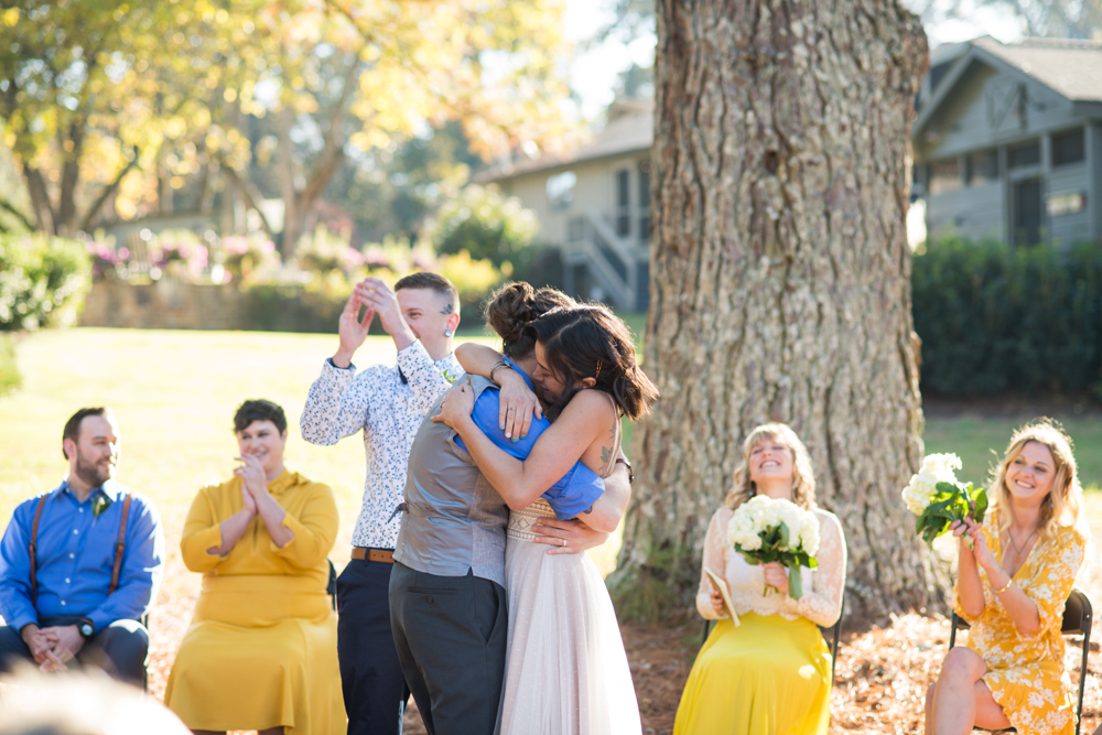 brides embrace following wedding ceremony at Ark on Lake Lanier photographed by You are Raven