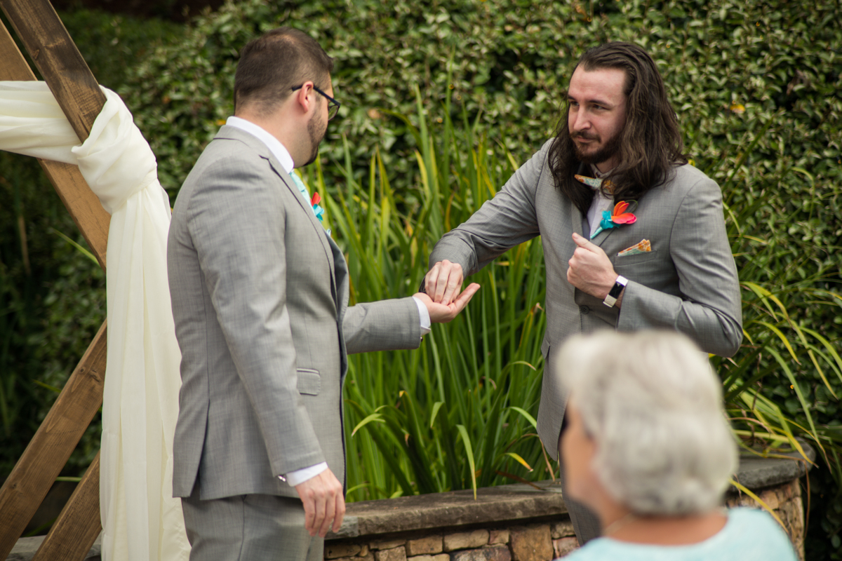 groomsman gives groom ring for wedding