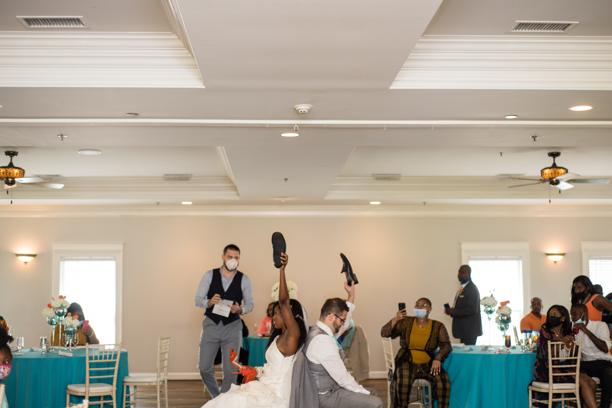 bride and groom play shoe game during wedding reception