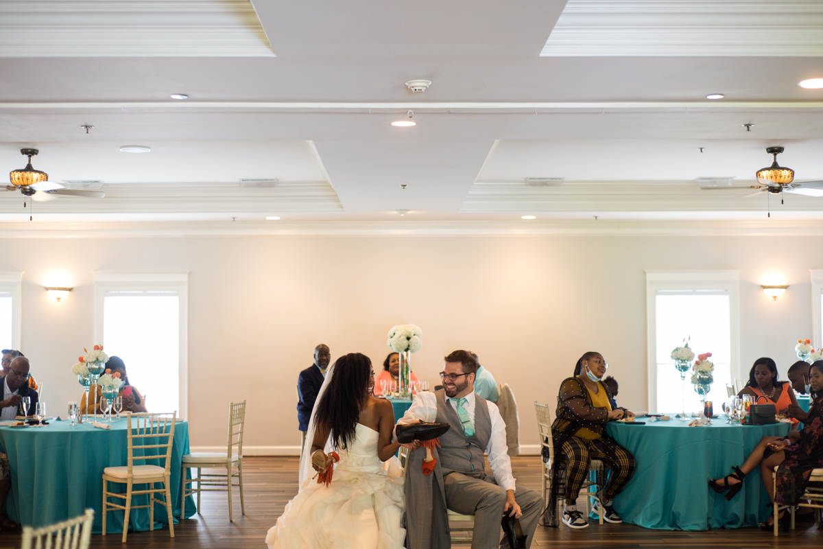 bride and groom play shoe game during wedding reception
